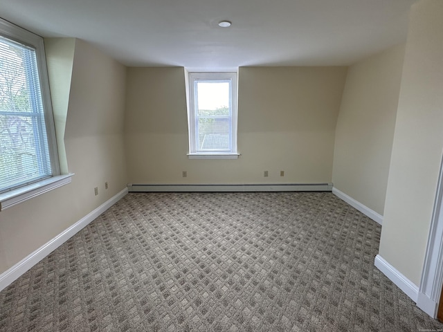 unfurnished room with a baseboard radiator, baseboards, and carpet floors