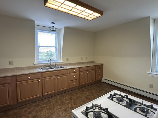 kitchen featuring light countertops, a baseboard heating unit, a sink, and white gas stove