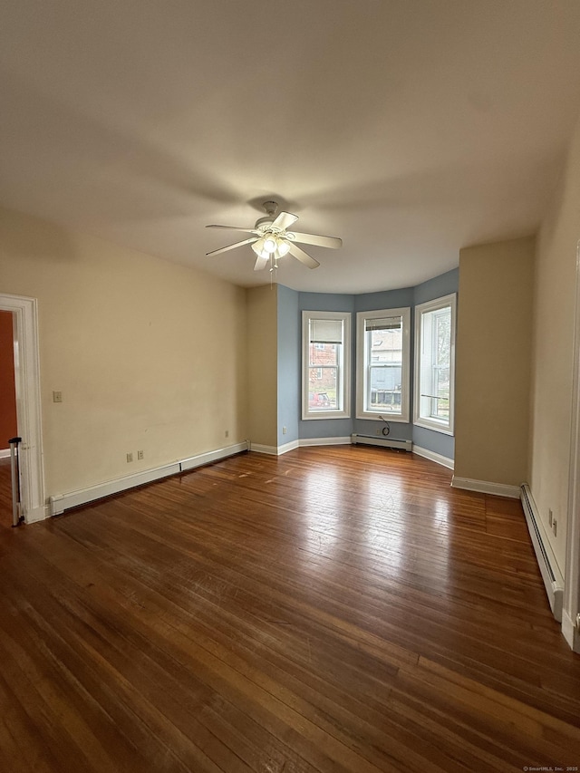 spare room featuring a baseboard radiator, a ceiling fan, baseboards, and dark wood-style floors