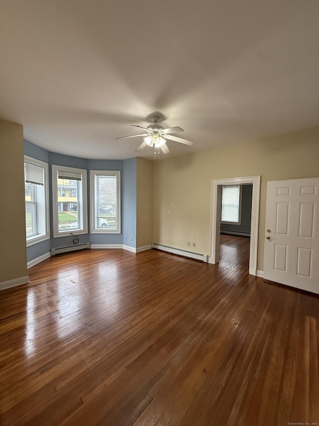 empty room with dark wood-type flooring, a baseboard radiator, baseboards, and ceiling fan