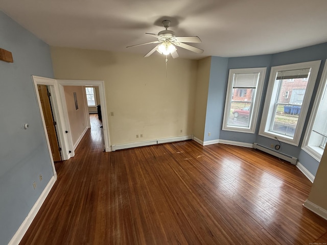 spare room with plenty of natural light, dark wood-type flooring, and a baseboard heating unit