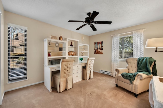 office space featuring light colored carpet, a baseboard heating unit, a ceiling fan, a textured ceiling, and baseboards