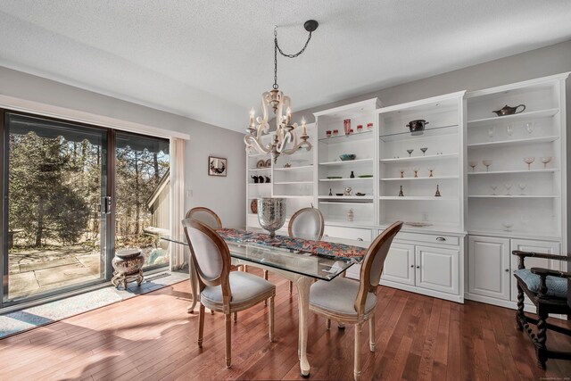 dining space featuring a notable chandelier, a textured ceiling, and dark wood-style flooring