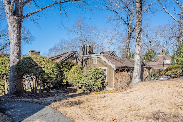 view of home's exterior featuring a garage and a chimney