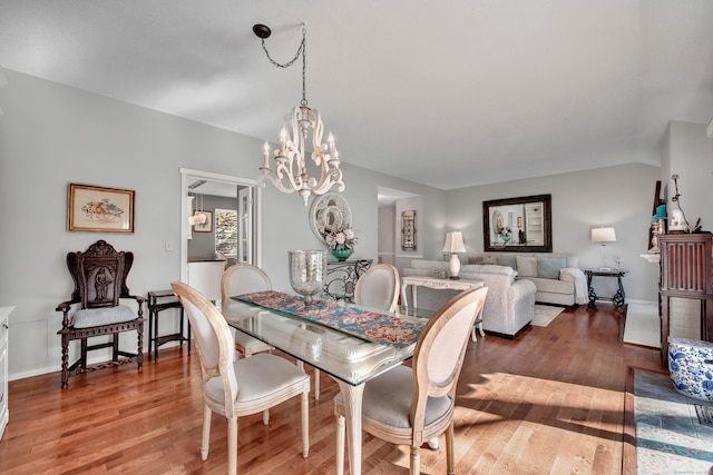 dining space with a notable chandelier, baseboards, and hardwood / wood-style floors