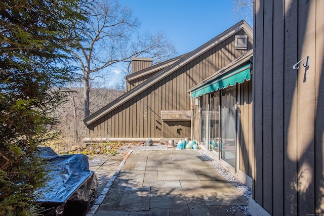 view of side of home featuring a patio and a chimney