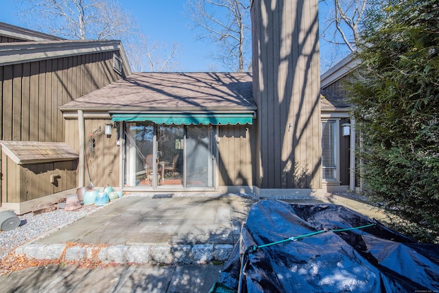 exterior space featuring a patio and a shingled roof