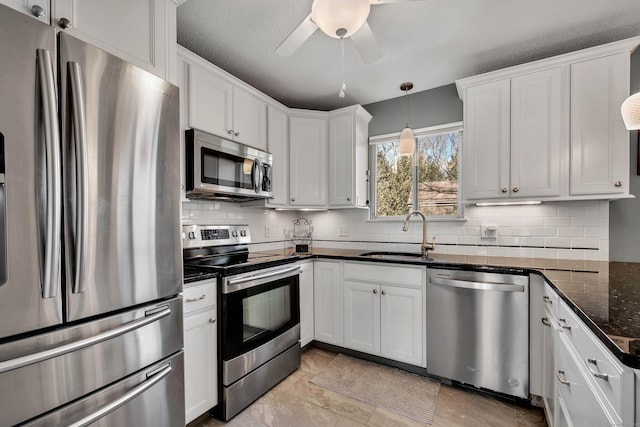 kitchen featuring decorative backsplash, white cabinetry, stainless steel appliances, and a sink