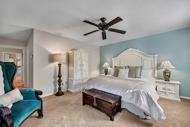 bedroom featuring carpet floors, a textured ceiling, baseboards, and a ceiling fan