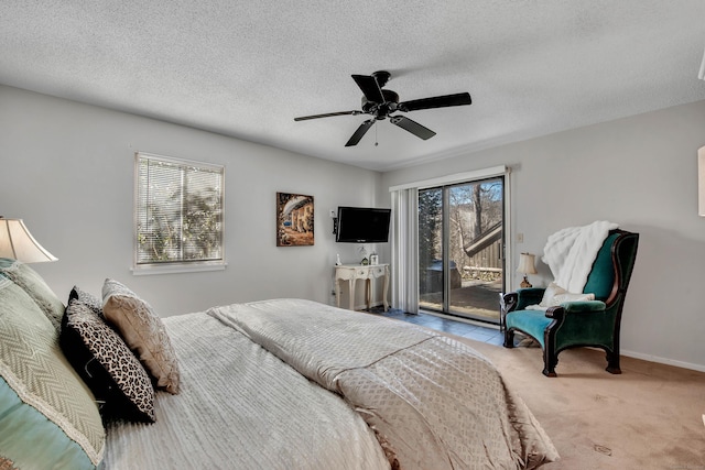 carpeted bedroom with a textured ceiling, access to outside, multiple windows, and ceiling fan