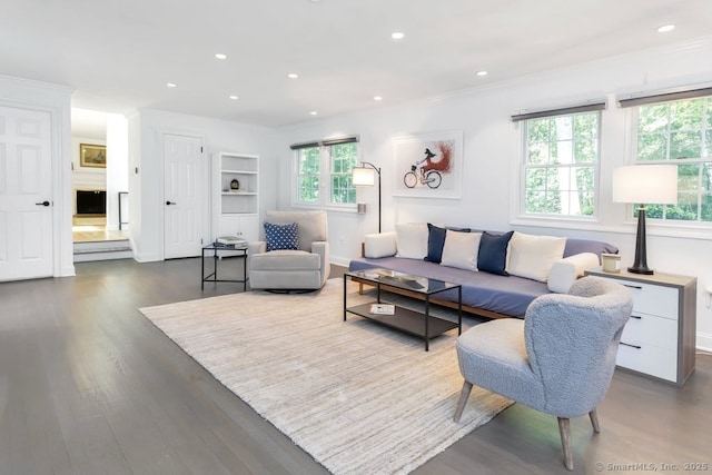 living area with a wealth of natural light, dark wood finished floors, and recessed lighting