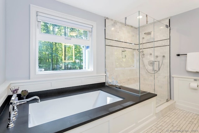 bathroom with a stall shower and a garden tub