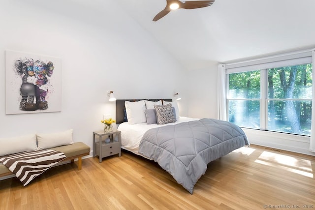 bedroom featuring light wood-style floors, vaulted ceiling, and ceiling fan