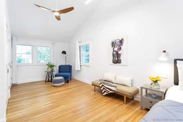 living area with light wood-type flooring, vaulted ceiling, baseboards, and ceiling fan