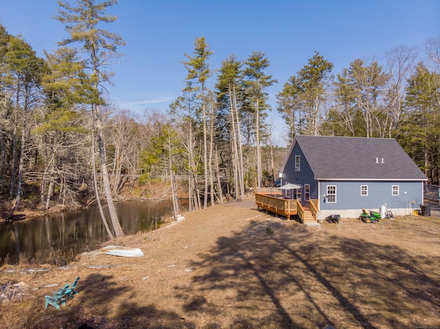 exterior space with a wooden deck and a shingled roof