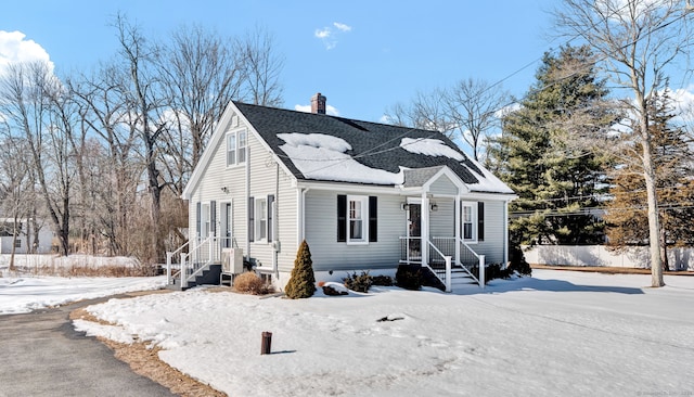 view of front of house featuring a shingled roof, a chimney, and fence