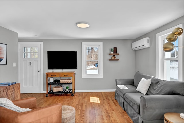 living area with baseboards, wood finished floors, and a wall mounted air conditioner