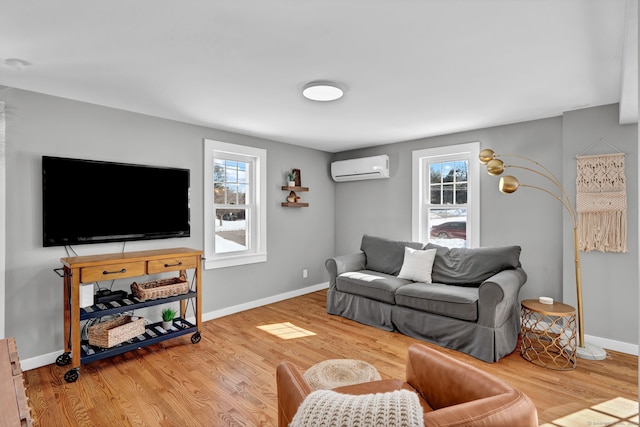 living area featuring a wall mounted air conditioner, wood finished floors, and baseboards