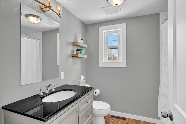 bathroom with visible vents, baseboards, toilet, wood finished floors, and vanity