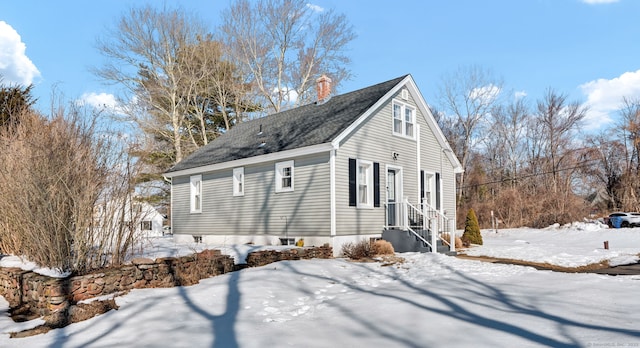 view of snow covered exterior featuring a chimney