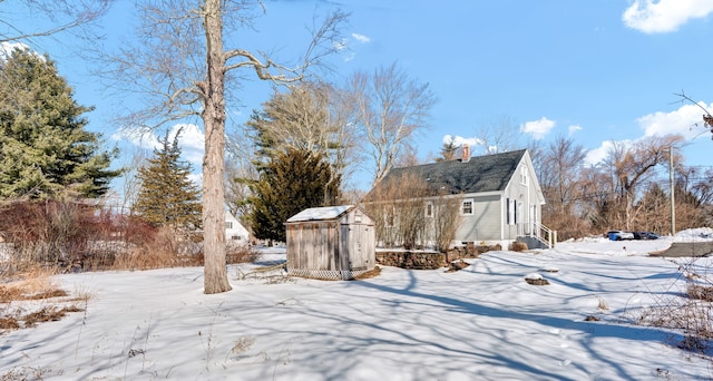 yard covered in snow with an outbuilding and a shed