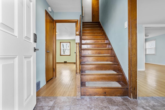 stairs featuring visible vents, baseboards, and wood finished floors