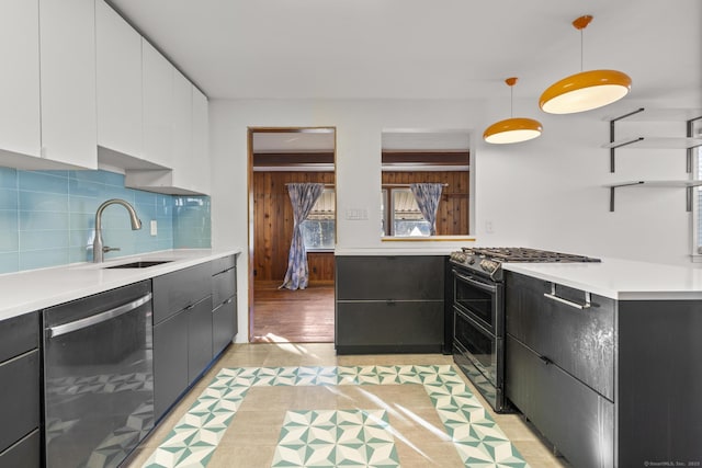 kitchen with tasteful backsplash, stainless steel appliances, light countertops, white cabinetry, and a sink