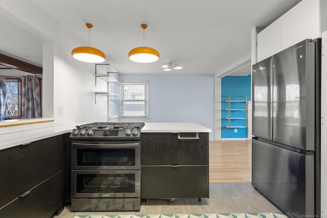 kitchen with stainless steel appliances, white cabinets, light countertops, and a peninsula