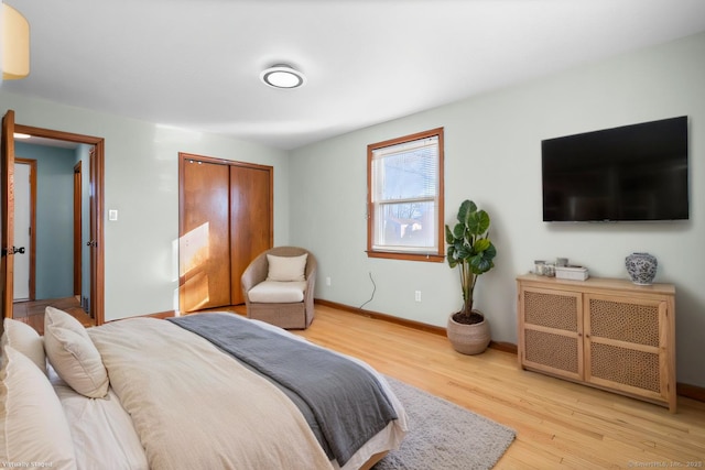 bedroom featuring a closet, wood finished floors, and baseboards