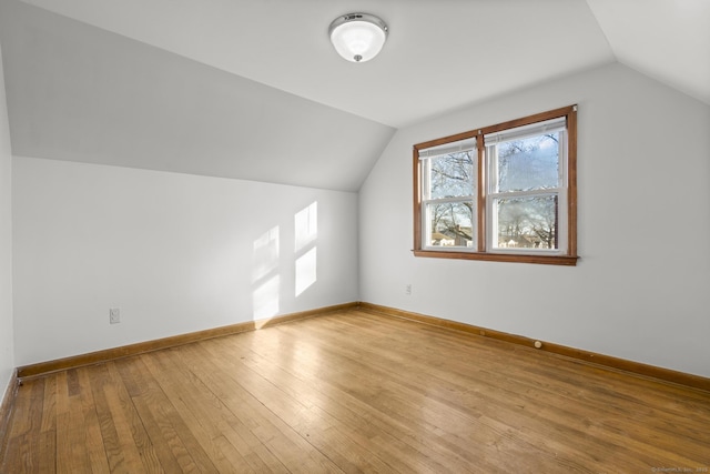 additional living space featuring lofted ceiling, baseboards, and hardwood / wood-style floors