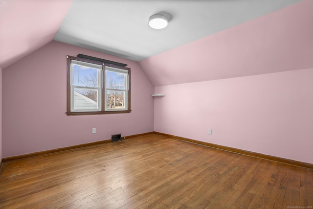 bonus room with hardwood / wood-style flooring, baseboards, and vaulted ceiling