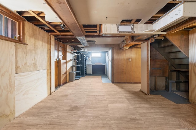 basement featuring stairs and wooden walls