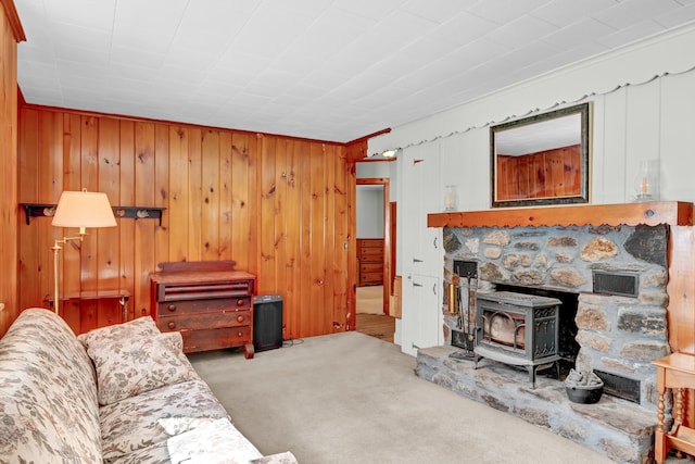 living area featuring carpet, a wood stove, and visible vents