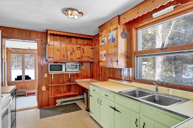 kitchen featuring a wealth of natural light, range, a sink, and wood walls