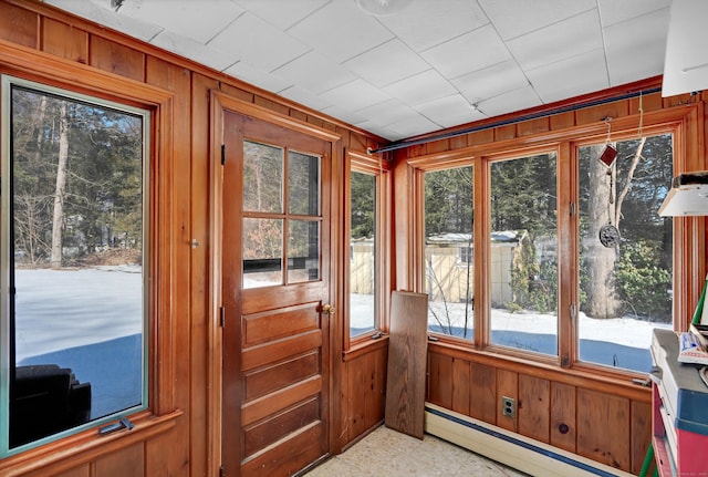 unfurnished sunroom featuring baseboard heating and a wealth of natural light