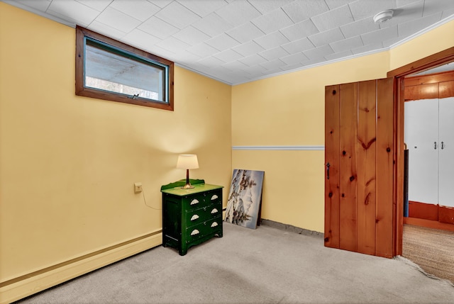 unfurnished room featuring a baseboard heating unit and carpet flooring