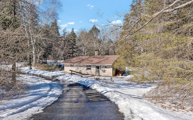 exterior space with stone siding and a chimney