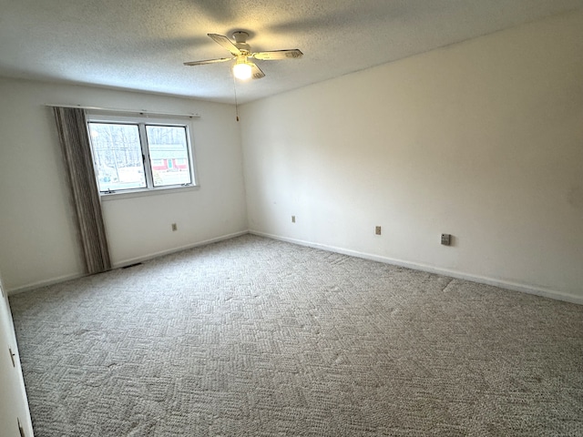 empty room featuring a textured ceiling, ceiling fan, carpet flooring, and baseboards