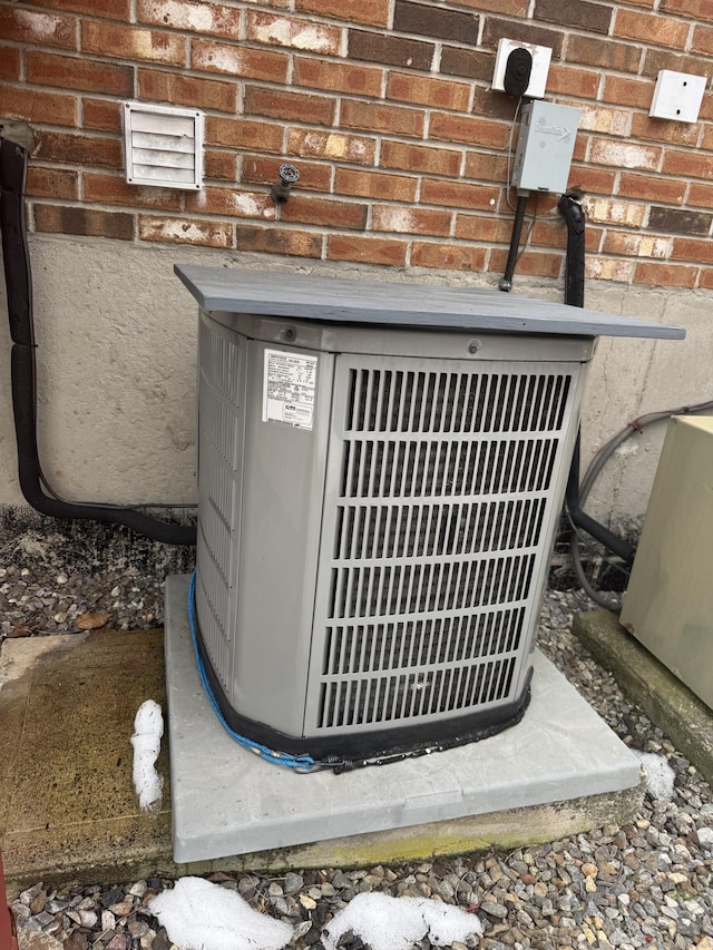 exterior details featuring cooling unit and brick siding