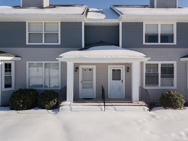 snow covered property entrance featuring a chimney