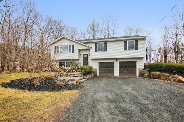 bi-level home with a garage and aphalt driveway