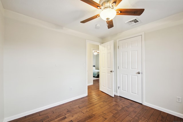 unfurnished bedroom with dark wood-style flooring, visible vents, ceiling fan, and baseboards