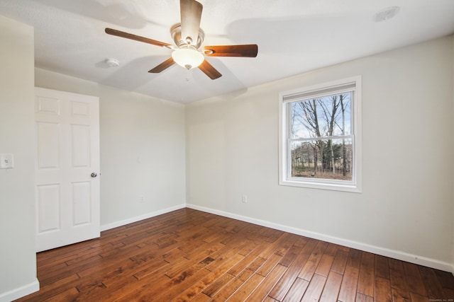 empty room featuring wood-type flooring, a ceiling fan, and baseboards