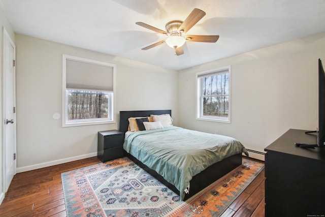 bedroom featuring a baseboard radiator, ceiling fan, baseboards, and hardwood / wood-style flooring