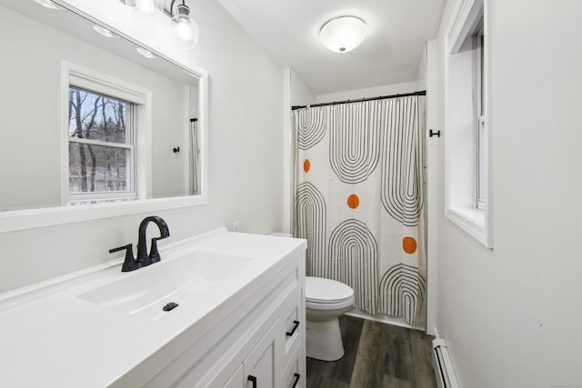 full bathroom featuring toilet, a shower with curtain, wood finished floors, baseboard heating, and vanity