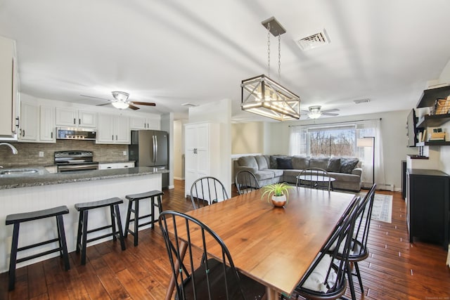 dining space featuring dark wood-style floors, visible vents, and ceiling fan