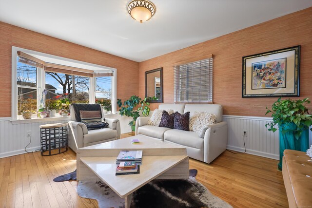 living area featuring a wainscoted wall and wood-type flooring