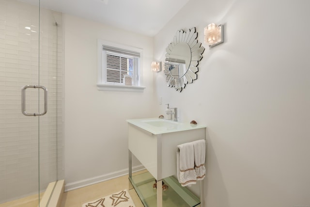 full bath with a stall shower, vanity, and baseboards