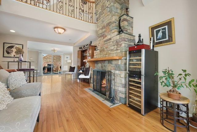 living room with wine cooler, a fireplace, and hardwood / wood-style floors