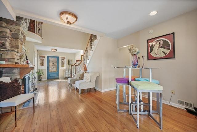 interior space featuring baseboards, stairway, visible vents, and hardwood / wood-style flooring